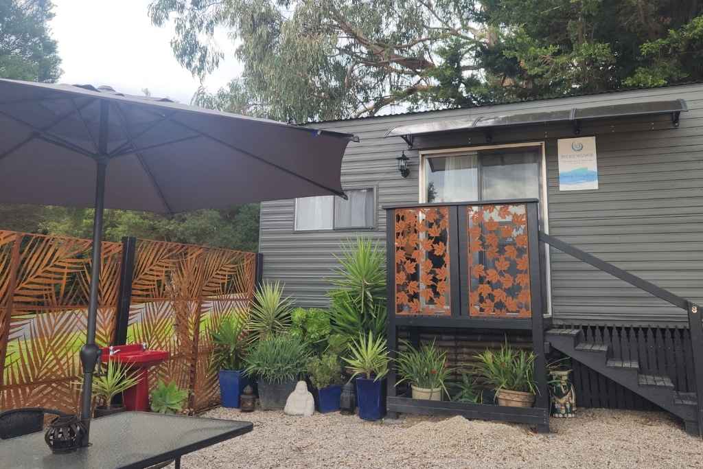 Exterior view of a peaceful treatment room surrounded by natural elements, inviting a sense of calm and holistic healing from the outside in.